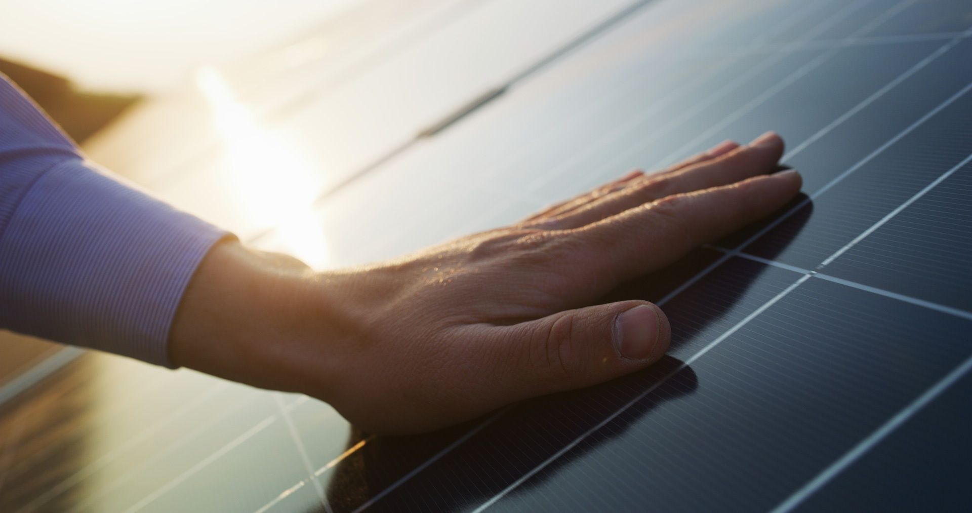 Nahaufnahme einer Hand auf einem Solarpanel